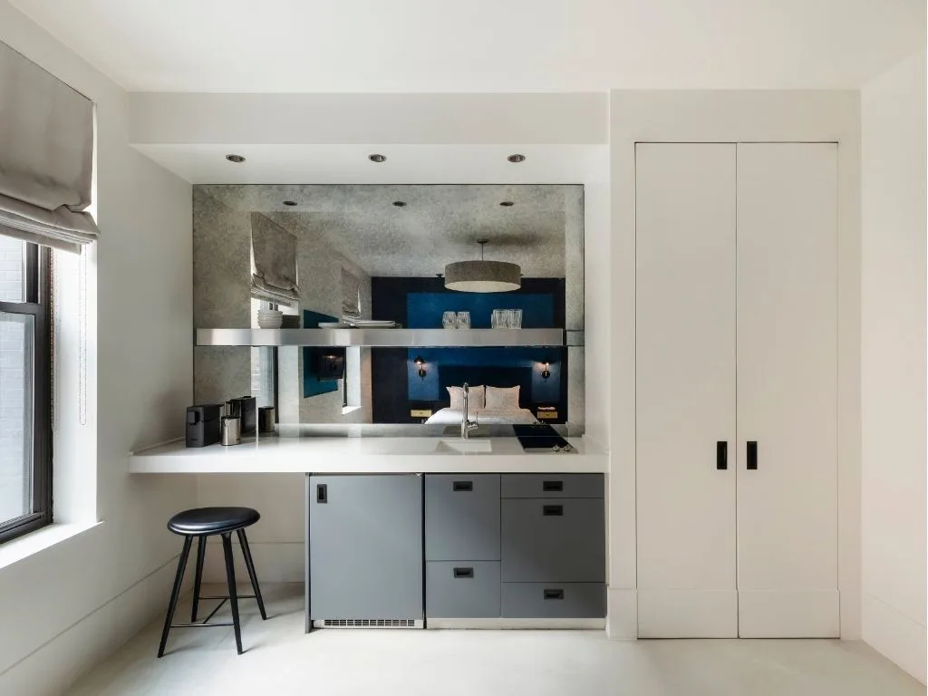 A small kitchen with white walls and gray cabinets.