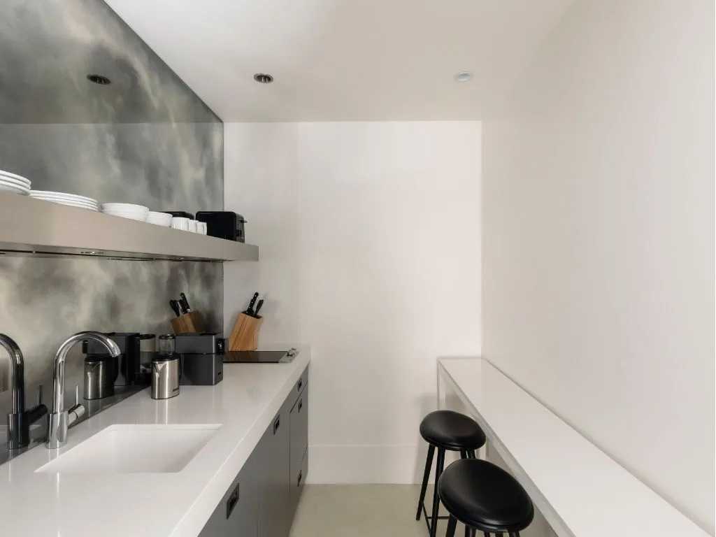 Modern kitchen with white countertops and gray cabinets.