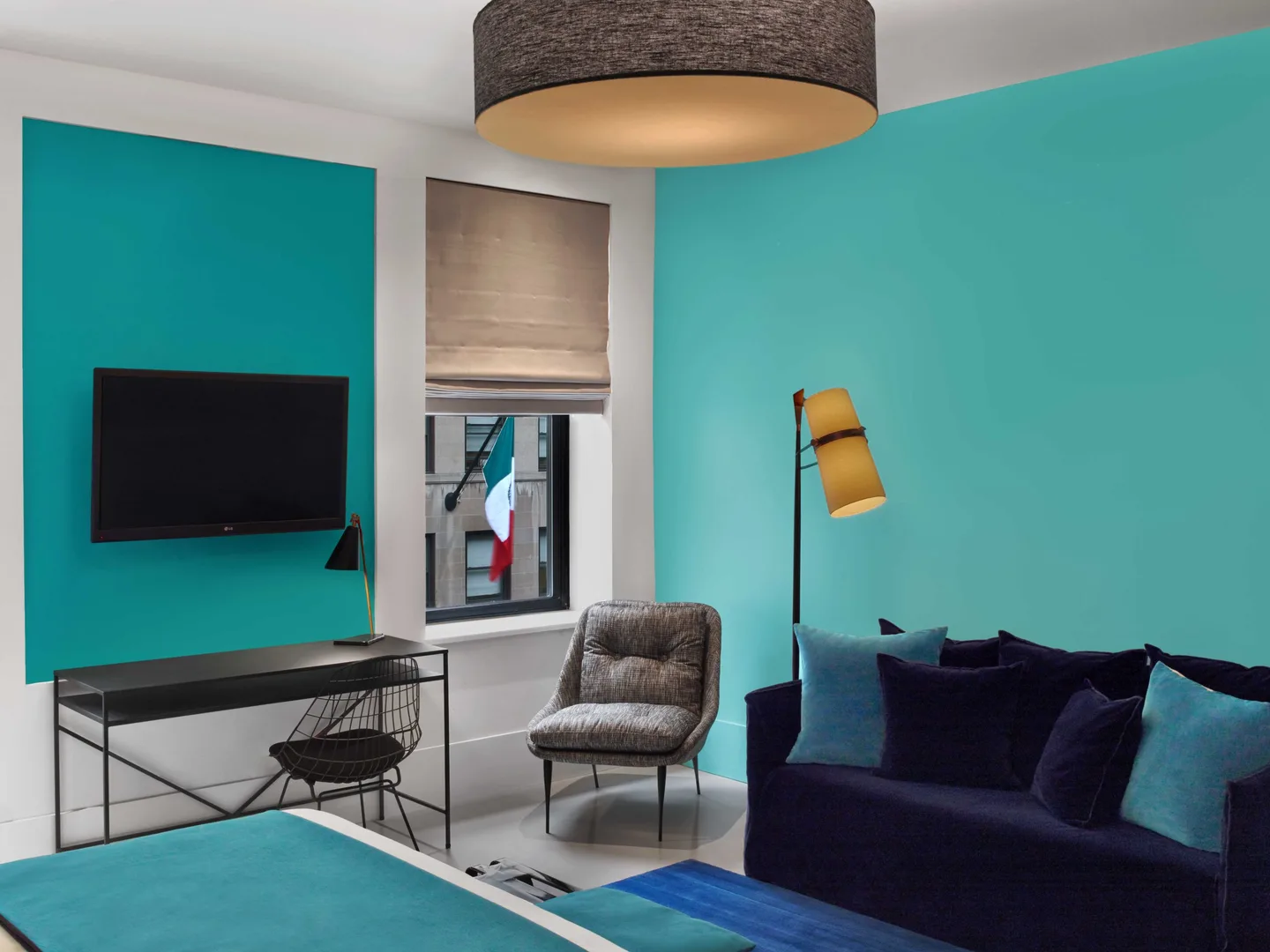 Seating area with velvet sofa, armchair and TV in the Standard Queen Room