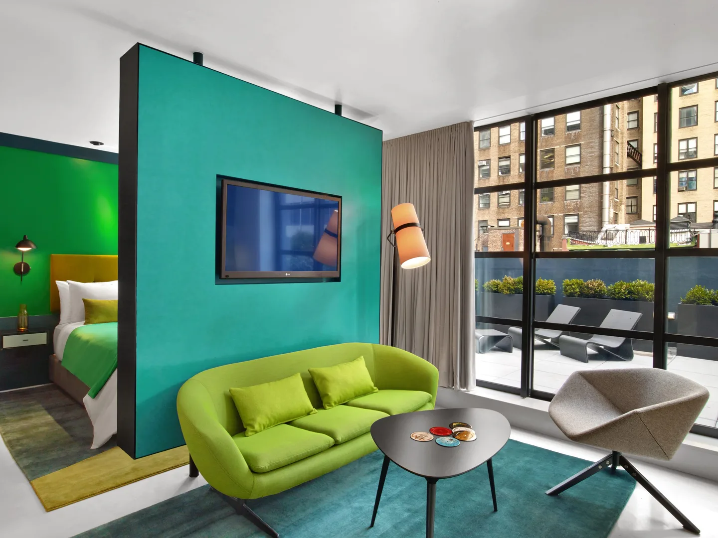 Superior Queen Room living area with lime sofa, teal divider wall and terrace views