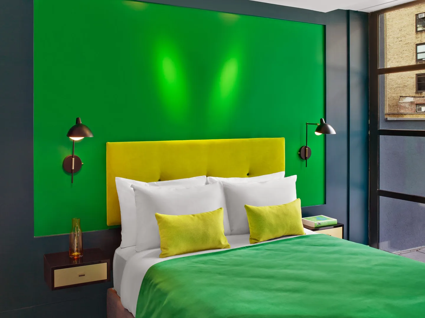 Queen bed with yellow headboard and green accent wall