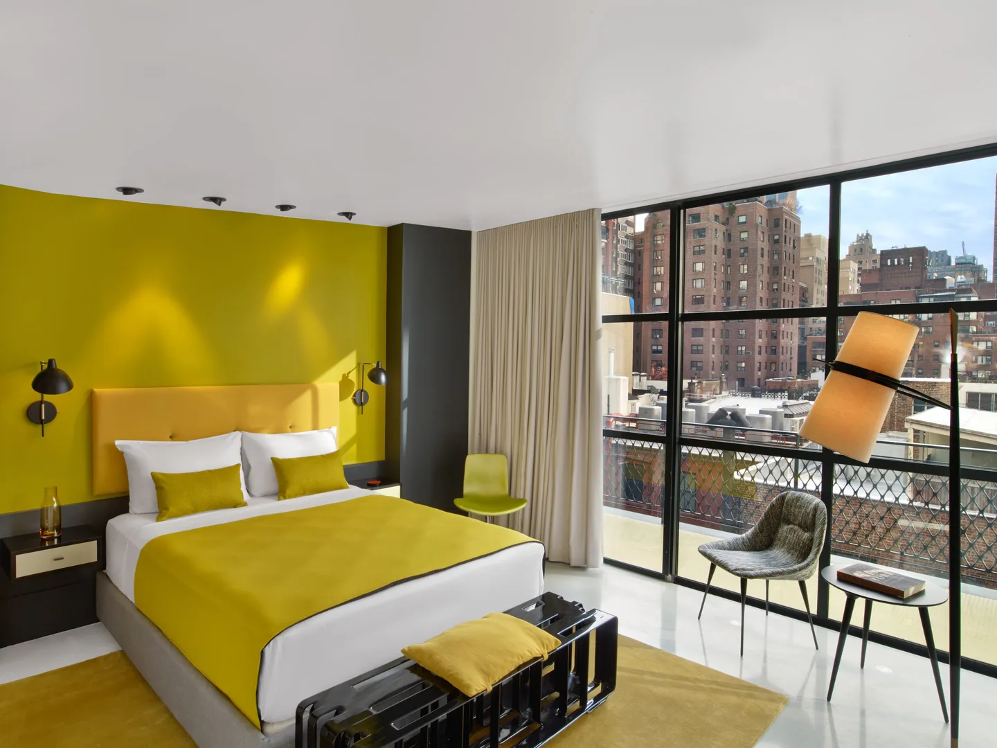 Penthouse Suite bedroom with yellow walls, queen bed and balcony views